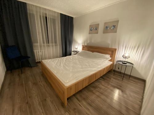 ein Schlafzimmer mit einem großen Bett und Holzboden in der Unterkunft Jasnogórska in Częstochowa