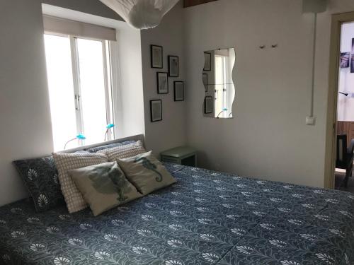 a bedroom with a bed with a blue comforter at Casa o Futuro in Alcobaça