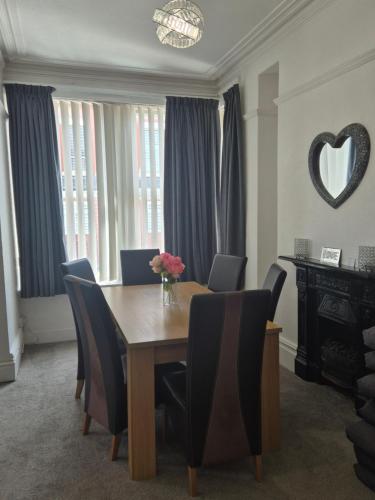 a dining room with a wooden table and chairs at Central Luxury Town House in Blackpool