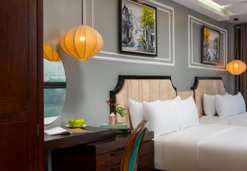 a hotel room with a bed and a desk and a window at Bella Rosa Hotel & Travel in Hanoi