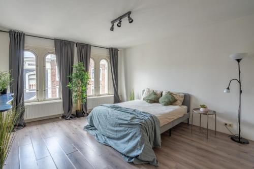 biała sypialnia z łóżkiem i 2 oknami w obiekcie Penthouse Amsterdam Dam Square w Amsterdamie