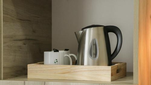 a coffee pot and two mugs on a wooden shelf at Tilia Hotel Beirut in Beirut