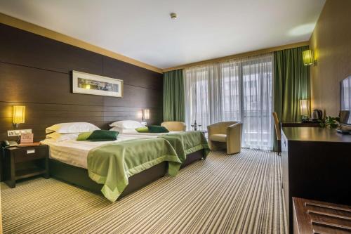 una habitación de hotel con una cama grande con cortinas verdes en Best Western Plus Olives City Hotel - Free Parking, en Sofía