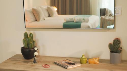 a mirror above a table with a bed in a room at Tilia Hotel Beirut in Beirut