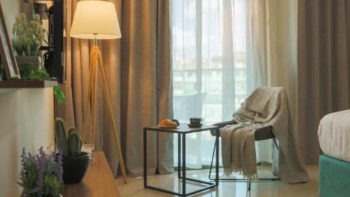 a room with a chair and a table and a lamp at Tilia Hotel Beirut in Beirut