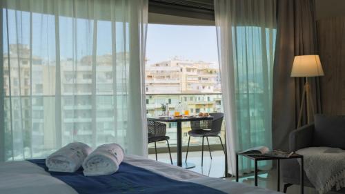 a hotel room with a bed and a view of a balcony at Tilia Hotel Beirut in Beirut