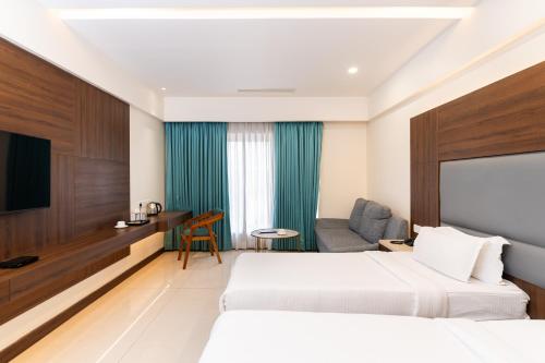 a hotel room with two beds and a tv at Pincode Hotels by Yatri Nivas in Secunderabad