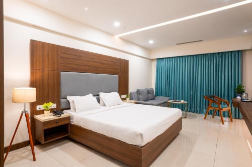 a bedroom with a bed and a desk and a chair at Pincode Hotels by Yatri Nivas in Secunderabad