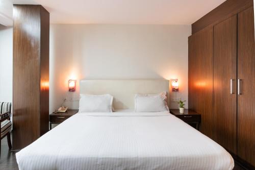 a bedroom with a large white bed and wooden cabinets at Pincode Hotels by Yatri Nivas in Secunderabad