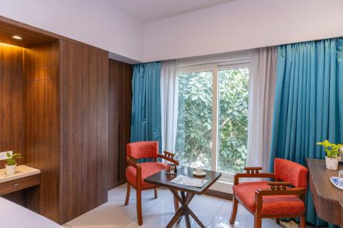 a room with a table and chairs and a window at Pincode Hotels by Yatri Nivas in Secunderabad