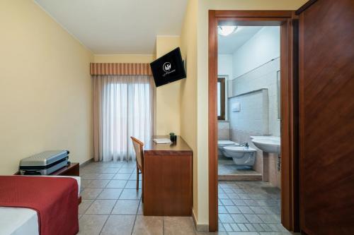 una camera con letto e scrivania e un bagno di Hotel La Fenice a Castel di Sangro