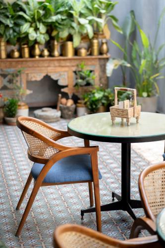 a table and chairs in a room with plants at Pincode Hotels by Yatri Nivas in Secunderabad