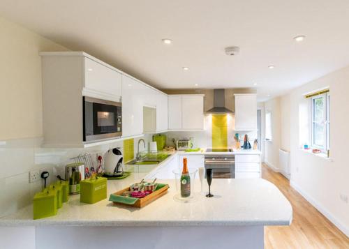 a white kitchen with a bottle of wine on a counter at The Retreat, own hot tub, romantic escape, near Lyme Regis in Lyme Regis