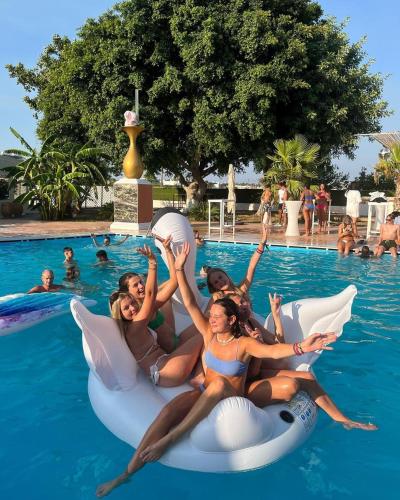 a group of people laying on inflatables in the swimming pool at BLACK AMBER BOUTIQUE HOTEL in Lampi