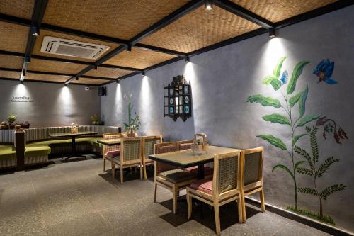 a restaurant with tables and chairs and a painting on the wall at Pincode Hotels by Yatri Nivas in Secunderabad