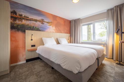 a bedroom with a large bed with a painting on the wall at Fletcher Hotel-Restaurant de Borken in Dwingeloo