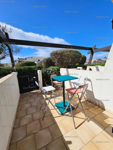 une table bleue et deux chaises sur la terrasse dans l'établissement Résidence Port Nature Colline 2 - Studio 2 pers - Port Nature Colline 2 MAE-6184, au Cap d'Agde