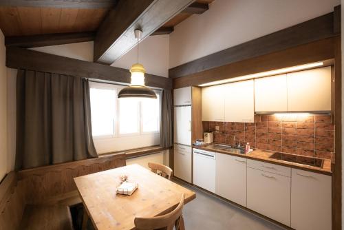 eine Küche mit einem Holztisch und einem Fenster in der Unterkunft Casa Viva Bad Ragaz in Bad Ragaz
