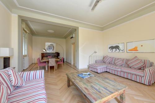 een woonkamer met twee banken en een salontafel bij Villa Ondina - Wonderful villa with private beach and big garden in Salò