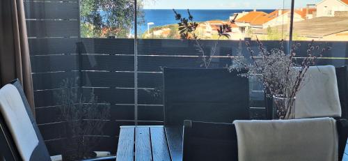 a balcony with a table and chairs and a window at Apartman Barry in Primošten