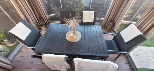 a table and chairs on a deck with a vase on it at Apartman Barry in Primošten