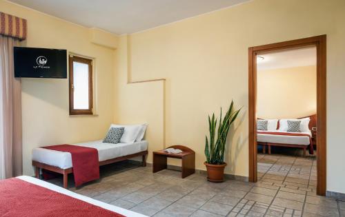 a room with two beds and a mirror at Hotel La Fenice in Castel di Sangro