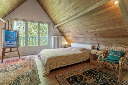 a bedroom with a bed and a chair and a window at Grande maison familiale in Douarnenez