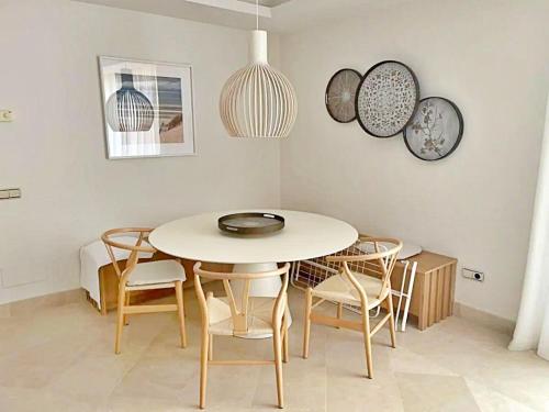 une salle à manger avec une table et des chaises blanches dans l'établissement Luxury 4 BD Penthouse with Private Pool by Hostlovers, à Marbella