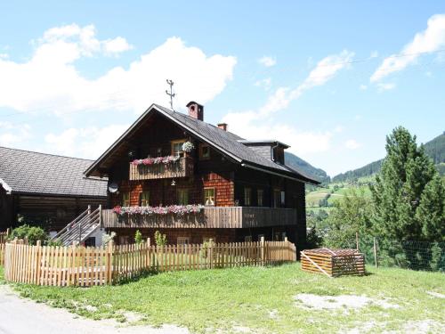 ein Holzhaus mit einem Zaun davor in der Unterkunft Sprawling Mansion near Ski Area in Salzburg in Eben im Pongau