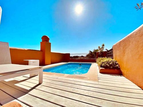 une arrière-cour avec une piscine et une terrasse en bois dans l'établissement Luxury 4 BD Penthouse with Private Pool by Hostlovers, à Marbella