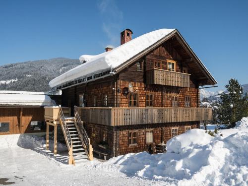 ein Blockhaus mit einem schneebedeckten Dach in der Unterkunft Sprawling Mansion near Ski Area in Salzburg in Eben im Pongau