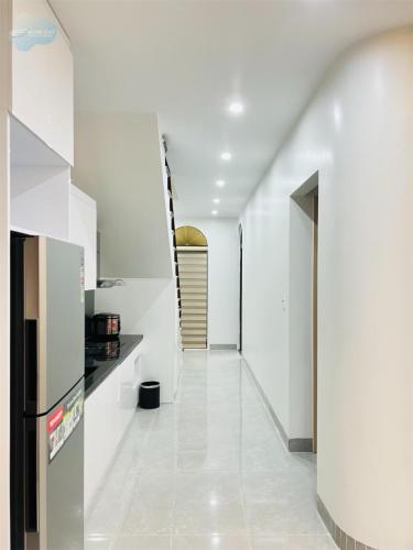 a white kitchen with white walls and a hallway at Villa Sonasea Vân Đồn by Deluxe Stay in Cái Rồng