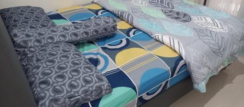 a bed with a comforter and pillows on it at Cordoba residence F5 in Tlekung