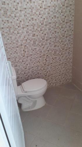 a bathroom with a white toilet in a brick wall at Cordoba residence F5 in Tlekung
