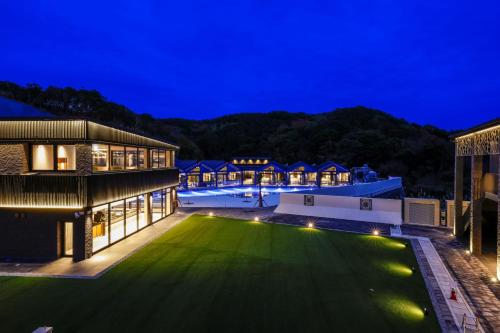 an estate with a green lawn at night at FIVE SPRING RESORT THE SHIRAHAMA in Shirahama