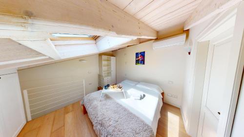 - une petite chambre avec un lit et un plafond dans l'établissement Appartamento Chervo Golf - BGL, à Pozzolengo