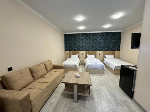 MeghriにあるVARDANANTS HOTEL Meghriのリビングルーム(ソファ、ベッド2台付)