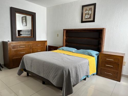 a bedroom with a bed and a dresser and a mirror at Casa Los Arrayanes in Guadalajara