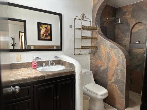 a bathroom with a sink and a toilet and a staircase at Casa Los Arrayanes in Guadalajara