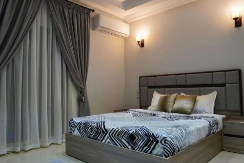 Schlafzimmer mit einem Bett mit einer blauen und weißen Bettdecke in der Unterkunft Central/3 bed/Private & Equipped in Madinat as-Sadis min Uktubar