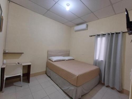 Ein kleines Zimmer mit einem Bett und einem Schreibtisch sowie einem Bett sidx sidx sidx sidx sidx. in der Unterkunft Hotel Villa Samperio in Poptún