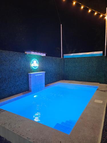 a swimming pool at night with lights on a wall at Ocean's Breeze Apartment and Rooms in Puerto Viejo