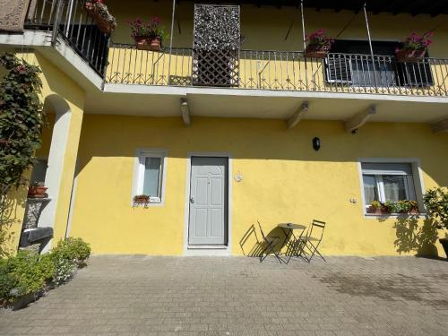 a yellow house with a table and chairs in front of it at I Limoni Casa Vacanza in Castelletto sopra Ticino
