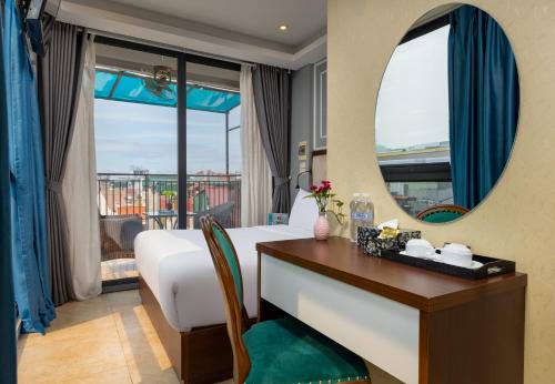 Schlafzimmer mit einem Bett, einem Schreibtisch und einem Spiegel in der Unterkunft Bella Rosa Hotel & Travel in Hanoi