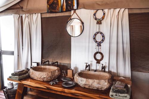 ein Badezimmer mit zwei Waschbecken auf einem Holztisch in der Unterkunft Ohorongo Tented Camp in Outjo