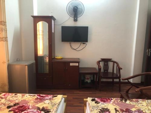 a living room with a tv on a wall at Hải Quân Motel in Ha Long