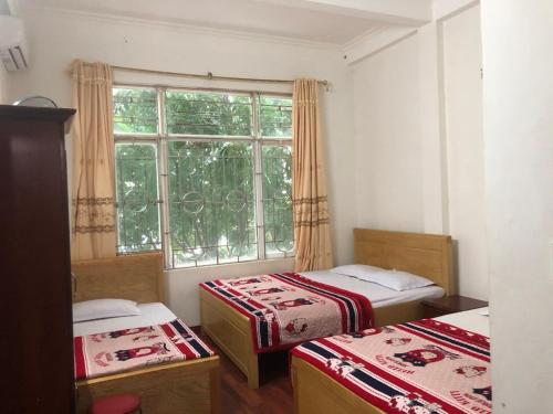 a small room with two beds and a window at Hải Quân Motel in Ha Long