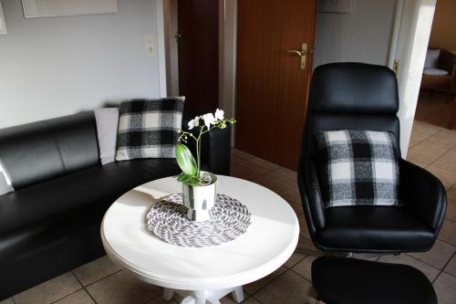 ein Wohnzimmer mit einem Sofa, einem Tisch und einem Stuhl in der Unterkunft De grote Linde in Heiligenhafen