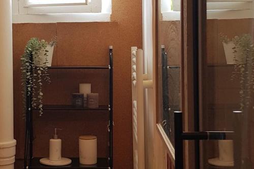 a bathroom with a shelf with candles and a mirror at Jungle Chic au bord du Canal Saint-Martin in Rennes