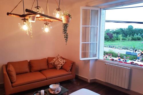 a living room with a couch and a window at Jungle Chic au bord du Canal Saint-Martin in Rennes